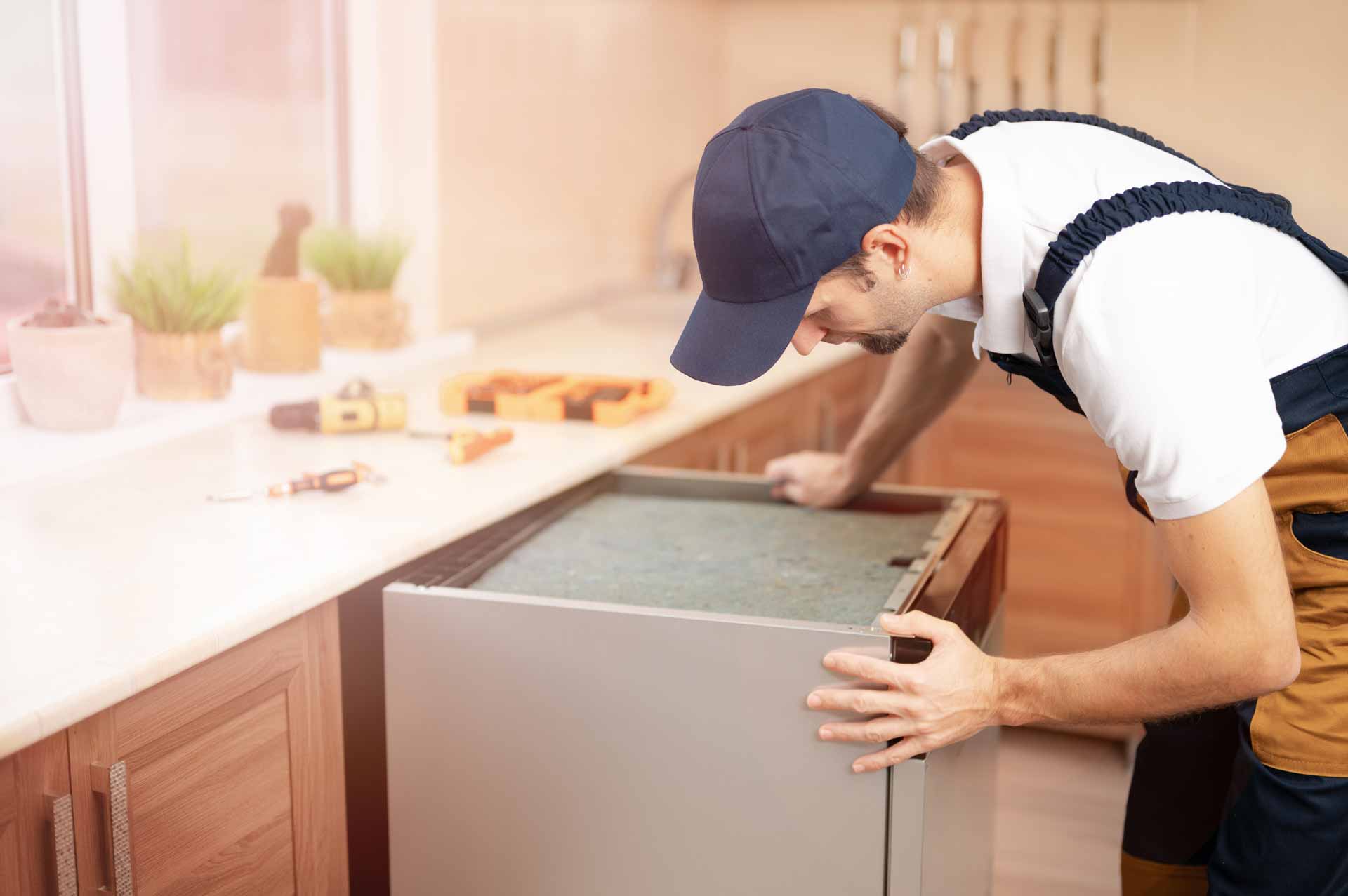 Appliance repair technician installing a new dishwasher