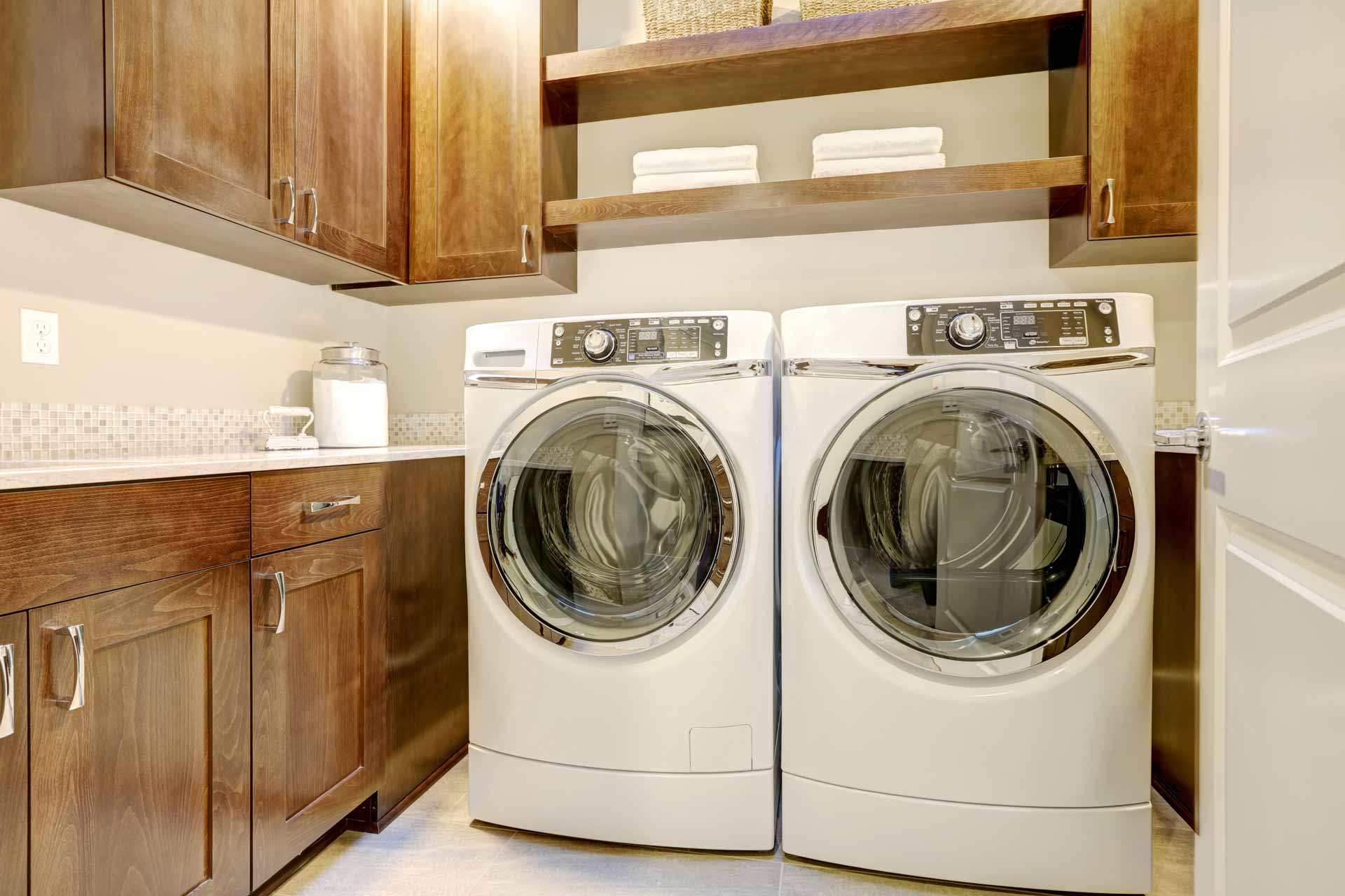Side-by-side washing machine and dryer in laundry room