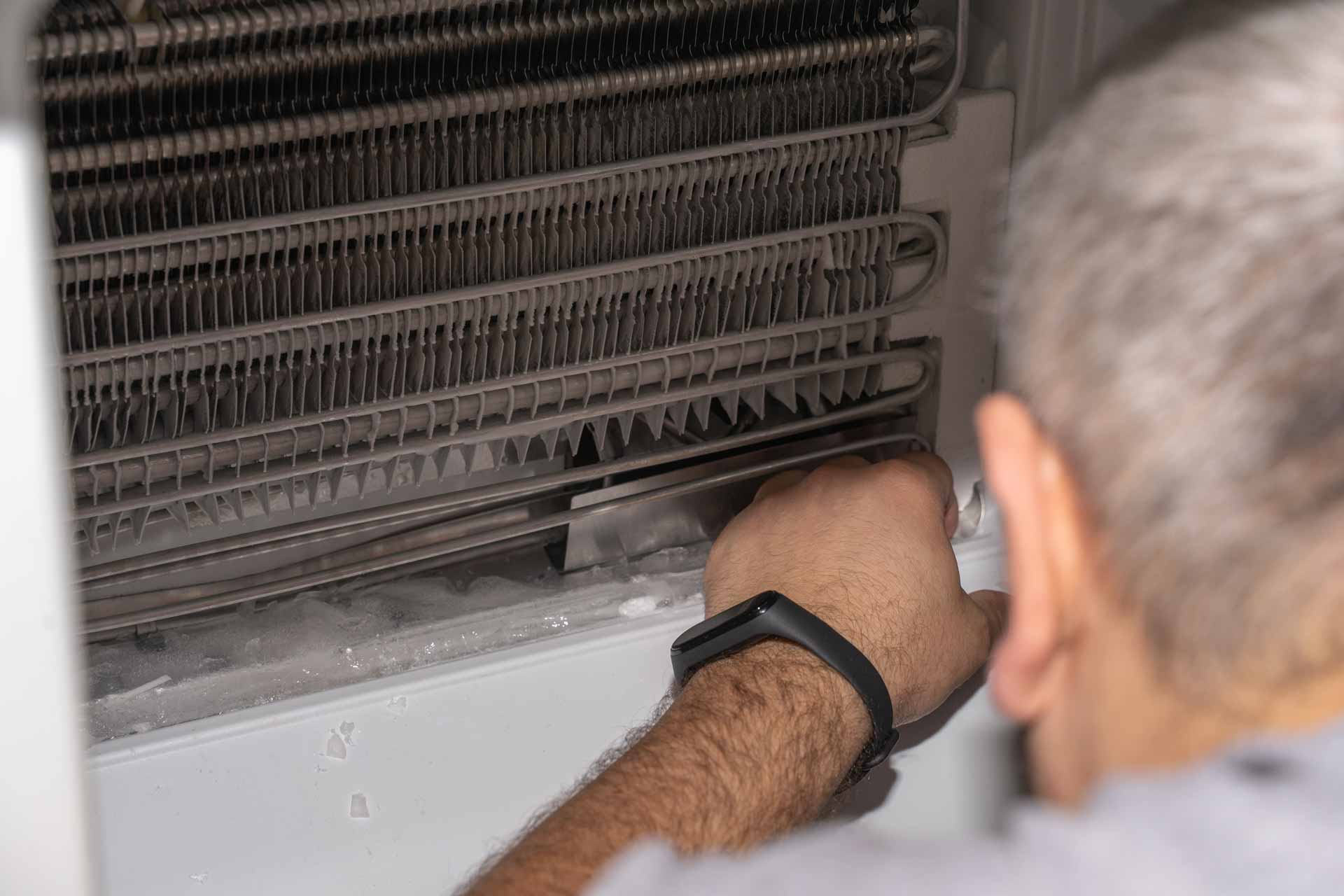 Appliance repair technician working on a freezer