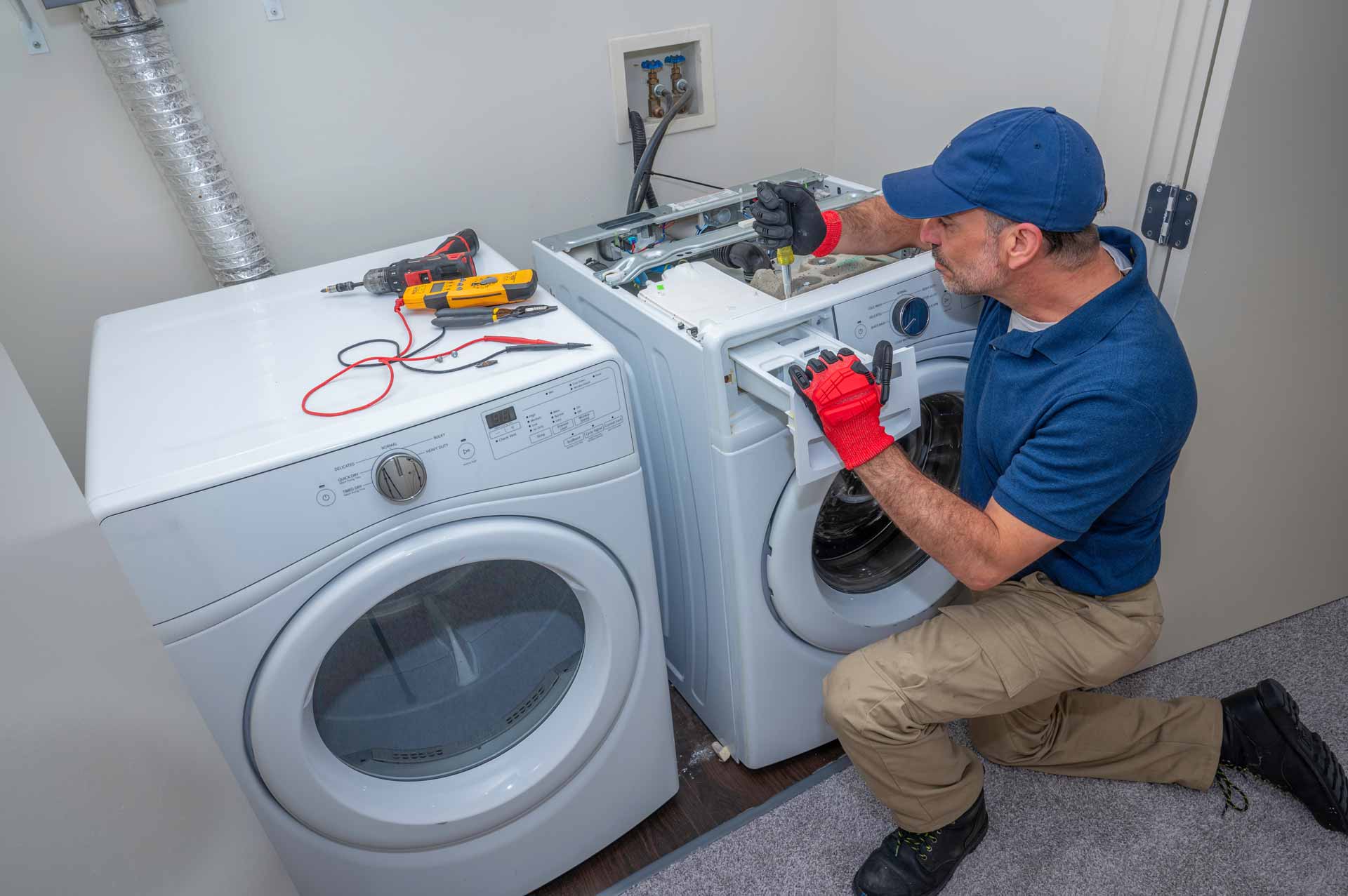 Appliance repair technician at work on washing machine