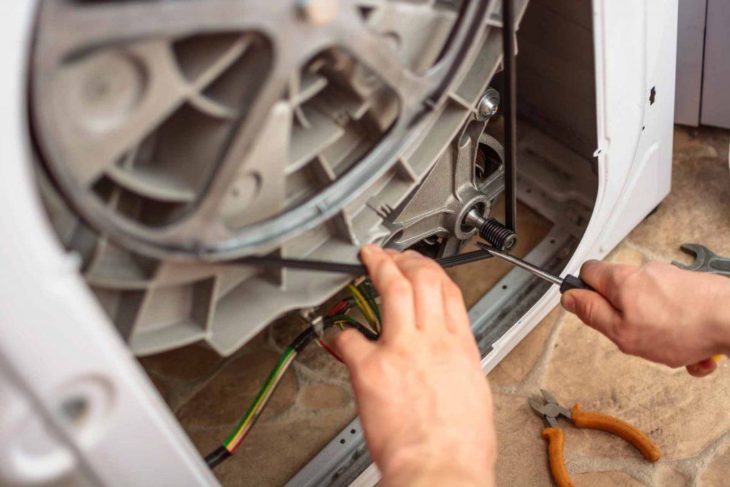 Appliance repair technician at work on a washer/dryer