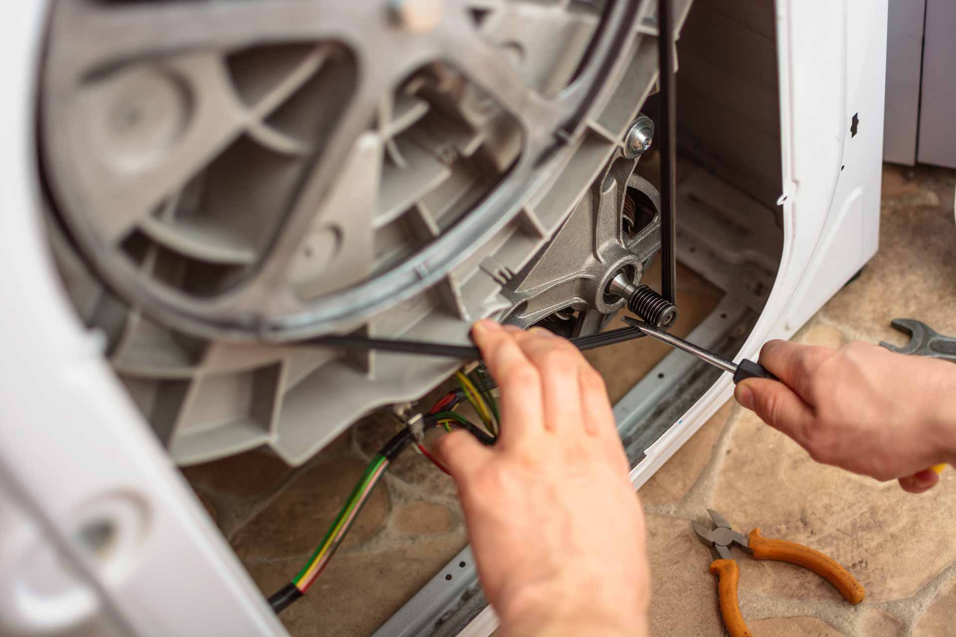 Appliance repair technician at work on a washer/dryer